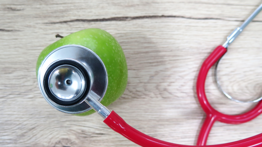 Estetoscópio em cima de maçã verde